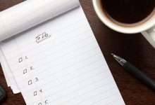 Photo of checklist, coffee, and pen on table