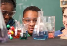 Middle school student looking at beakers in science class